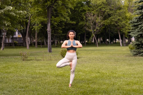 Gün doğumunda halka açık parkta yoga yapan güzel bir kadın.