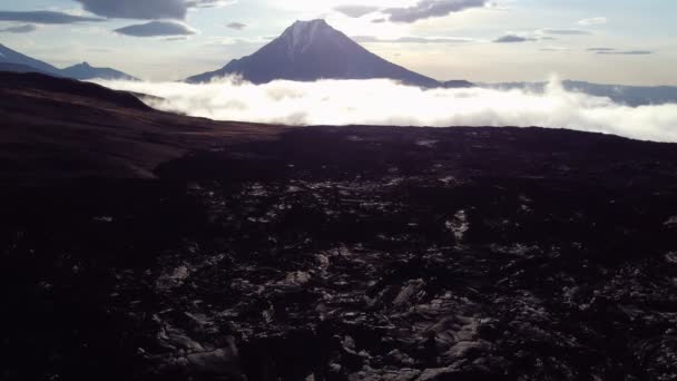 Lava floor at dawn against the background of a volcano — Stockvideo