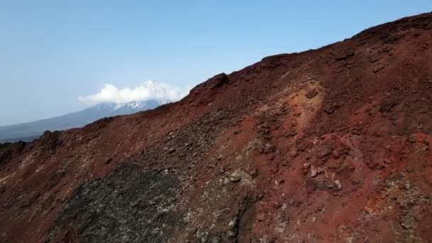 Montaña roja con una vista de volcanes de nieve — Vídeo de stock