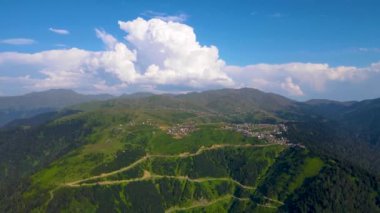 Dron uçuşu dağların üzerinde ve kalın beyaz bulutların üzerinde. Gomis Gürcistan