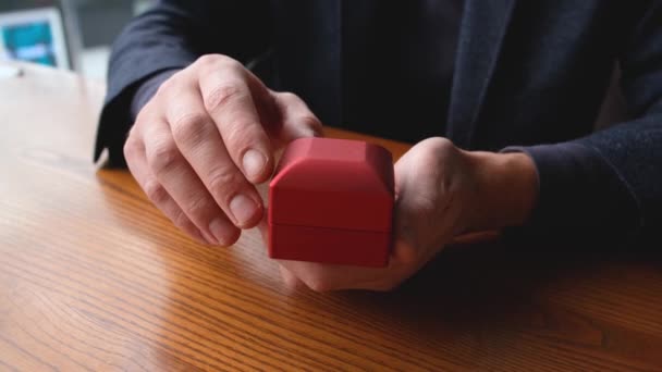 Les mains d'un homme ouvrent une boîte avec une alliance — Video