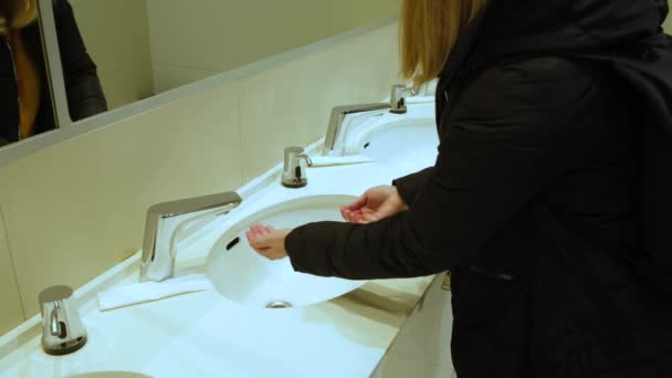 Een vrouw wast haar handen met zeep in een openbaar toilet — Stockvideo