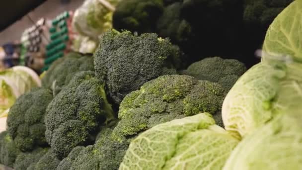 En el departamento de hortalizas de un supermercado manos masculinas tomar una bomba de brócoli — Vídeos de Stock