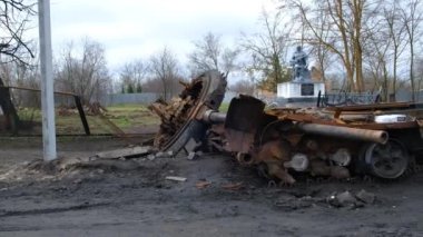 a wrecked military vehicle against the backdrop of a monument to a soldier in Ukraine. Irpin-Kyiv- April 2022
