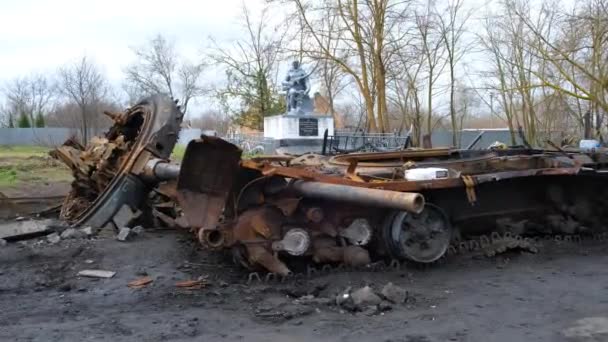 A wrecked military vehicle against the backdrop of a monument to a soldier in Ukraine. Irpin-Kyiv- April 2022 — стокове відео