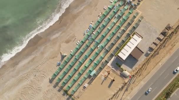 Spiral flight over the hotels tourist beach with sunbeds and awnings — Video Stock