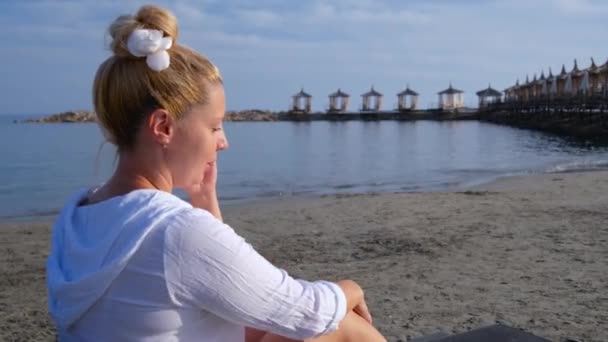 一个穿着白衬衫的女孩在海滩上自拍 — 图库视频影像