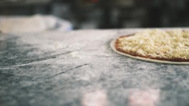 Yarı bitmiş dört peynirli pizza, restoranın mutfağında yemek pişirmeden önce masada. Yüksek kalite 4k görüntü