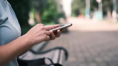 Akıllı telefon kullanarak ve tutarak genç kadın ellerini kapat, dokunmatik ekranda aşağı yukarı kaydır. Yüksek kalite 4k görüntü