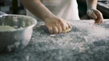 Bir şef pizza unundan hamuru elleriyle yoğurur ve bir pasta yapar. Camın arkasından bak. - Evet. Yüksek kalite 4k görüntü