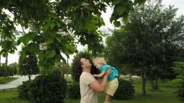 Baba oğul parkta. Baba oğlunu fırlattı. Mutlu aile kavramı. Baba parkta oğluyla oynuyor. - Evet. Yüksek kalite 4k görüntü