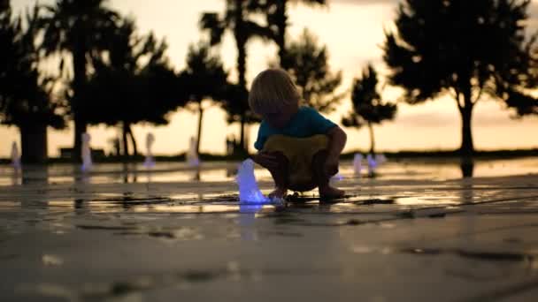 Een Klein Kind Buiten Spelen Met Water Uit Een Bodemfontein — Stockvideo