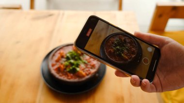 Blog yazarı kız akıllı telefonunda hindi salatası ile yemek yiyor. Yüksek kalite 4k görüntü