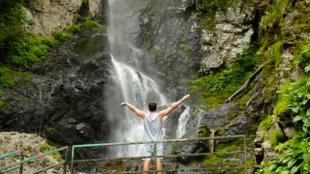 Man Raises His Hands Background Mervisi Waterfall Georgia Rear View — Stock Video