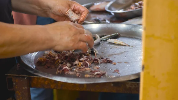 womens hands clean small fish with their hands at the fish market. Fish industry. High quality 4k footage