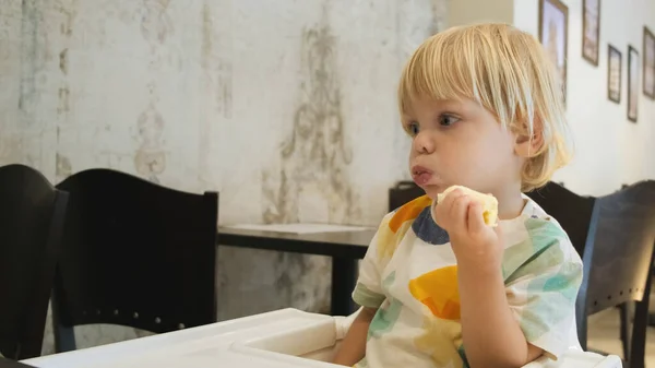 Attractive Boy Eats Banana Sits Table Restaurant Carefully Watching Cartoons — Fotografia de Stock