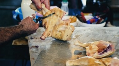 Pazarda tavuk kesen beyaz bir adamın elleri. Çiğ tavuğu parçalara ayırmak. Yüksek kalite 4k görüntü