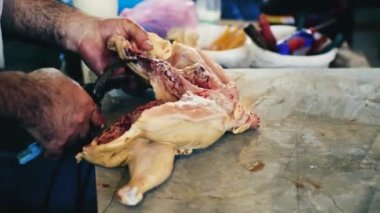 Pazarda tavuk kesen beyaz bir adamın elleri. Çiğ tavuğu parçalara ayırmak. Yüksek kalite 4k görüntü
