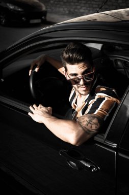 Alicante şehrinde model kılığında sakallı yakışıklı, esmer adam arabasıyla içeri girdi.