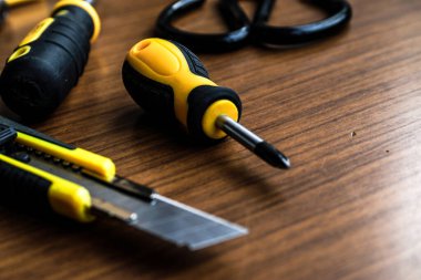 Çeşitli sarı alet seti, tornavida, pense, testere.