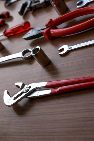 Çeşitli kırmızı alet seti, tornavida, pense, testere.