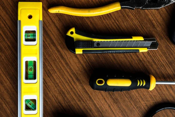 Çeşitli sarı alet seti, tornavida, pense, testere.