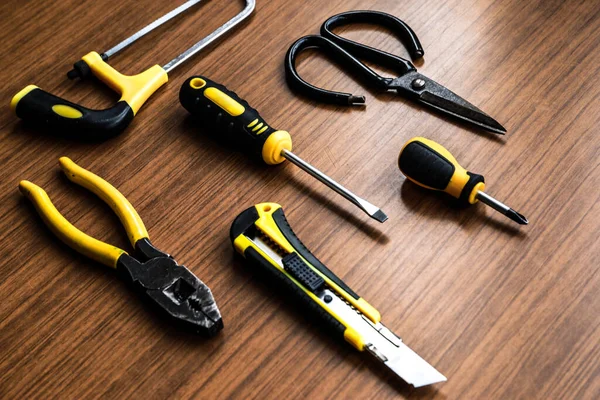 Çeşitli sarı alet seti, tornavida, pense, testere.