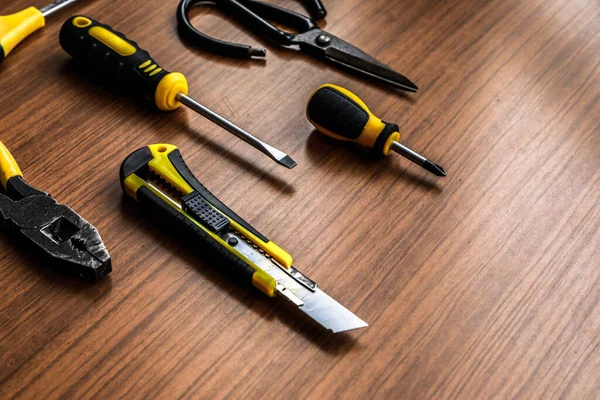 Çeşitli sarı alet seti, tornavida, pense, testere.