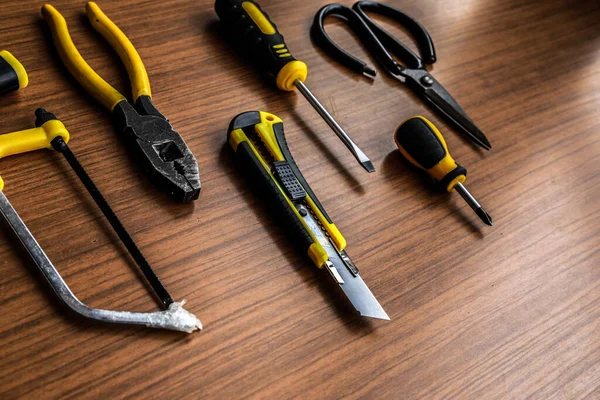 Çeşitli sarı alet seti, tornavida, pense, testere.