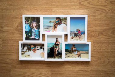 Yazın Mallorca sahillerinde birbirini seven bir çiftin birkaç fotoğrafının beyaz çerçevesi. Kahverengi ahşap bir arka planı var.