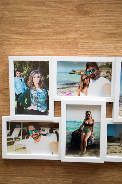 Yazın Mallorca sahillerinde birbirini seven bir çiftin birkaç fotoğrafının beyaz çerçevesi. Kahverengi ahşap bir arka planı var.