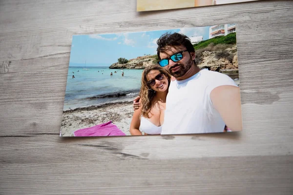 Photo of a couple in love on vacation, they are on a trip on the beaches of Mallora. with a gray wooden background.