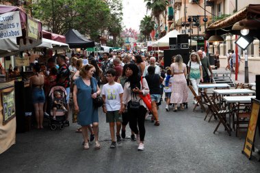 Alicante, İspanya; 21 Haziran 2022: Alicante Şenlik Yangınları, insanlar Foguera Carolinas Altas yakınlarındaki sokak pazarına bakarken sokaklarda şenliklerle yürüyorlar.