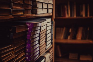 Old textbooks on dark bookshelves