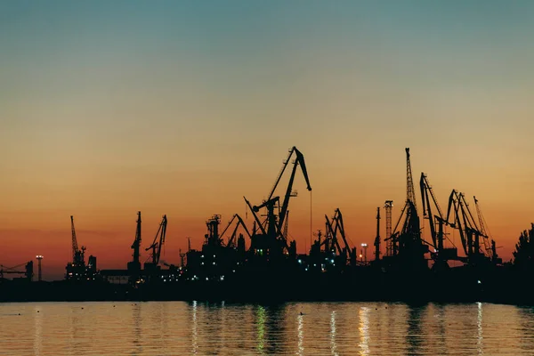 Sunset behind the silhouette of the port