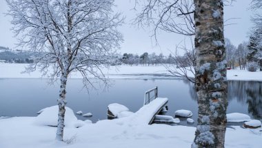 Kış boyunca kar yağan huzurlu İsveç Gölü. Tatillerde, gezilerde ve maceralarda dinlenmek için inanılmaz bir manzara.