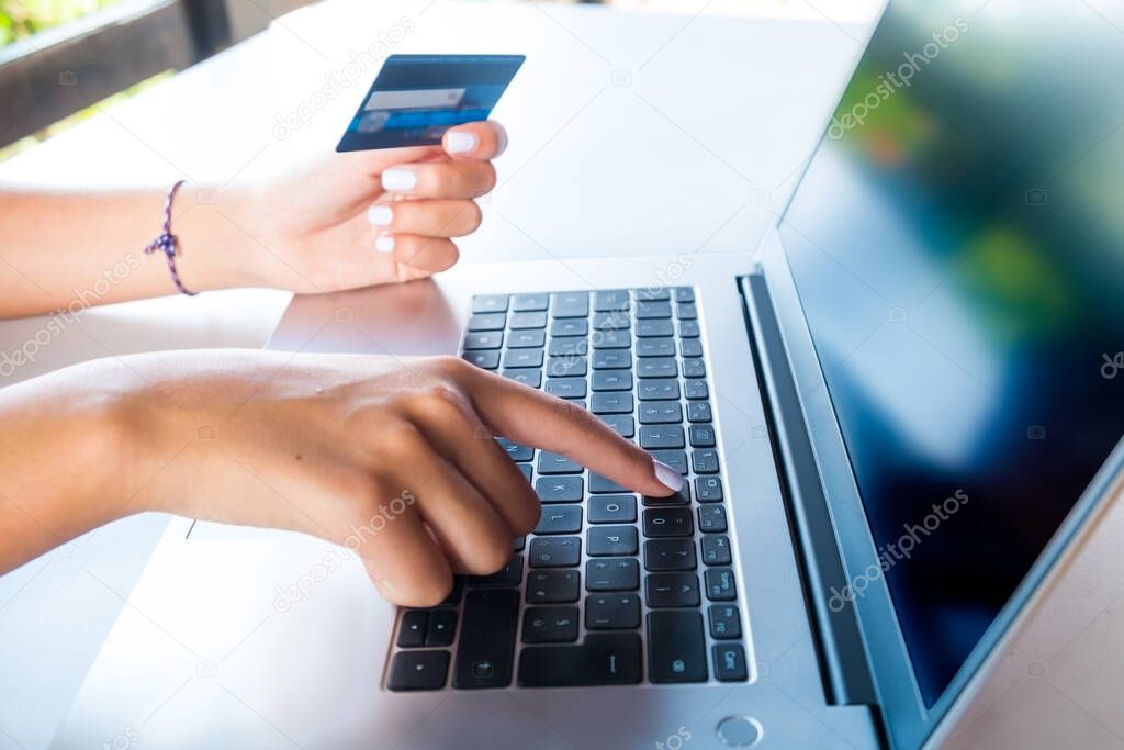 Female hands on a keyboard and holding credit card for shopping on e-commerce website. Useful for advertising, sales and promo.Screen customizable with websites screenshot.
