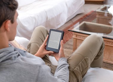 Genç adam dijital tablet aygıtı hakkında bir e-kitap okuyor