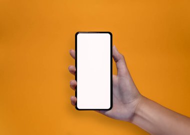 Hands holding a smartphone on yellow background. Template concept for app, mobile websites, social content