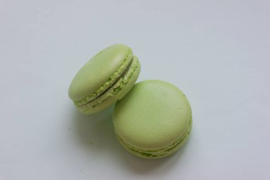 Two green macaroons on a white table, a top view of pistachio macarons