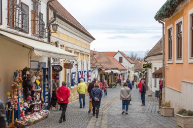 Szentendre, Hungary - March 10, 2019: Tourists walk along cozy street with souvenir shop