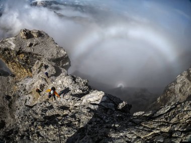 Looking down the abyss while climbing a high mountain with incredible rounded light effect in Dolomite