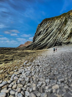 Çizgisel sinek ve yuvarlak taşlar ile etkileyici kompozisyon ve sonunda iki yürüyüşçü, Bask Ülkesi.
