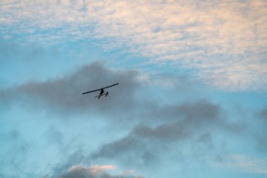 A seaplane flying from far sky in sunset