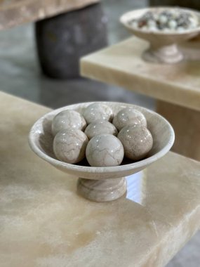 The container made of marble is like a plate and ball on top