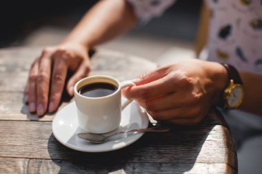 close up mug of delicious fragrant coffee on the table in the hands