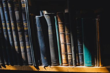 old books on the shelf in the library under the sun ray