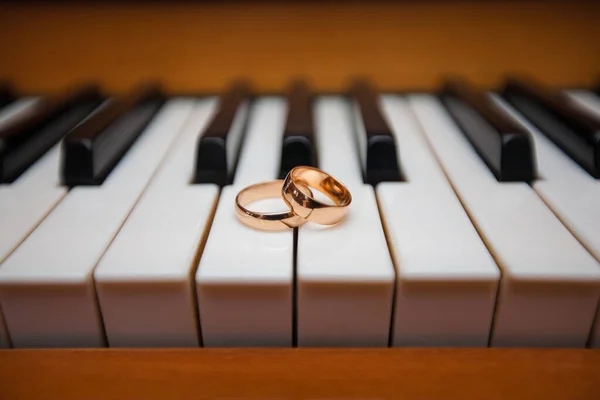 ピアノの鍵盤をゴールドの結婚指輪 — ストック写真