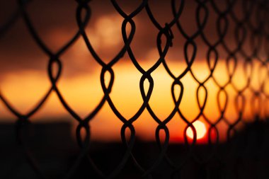 sunset through mesh fence