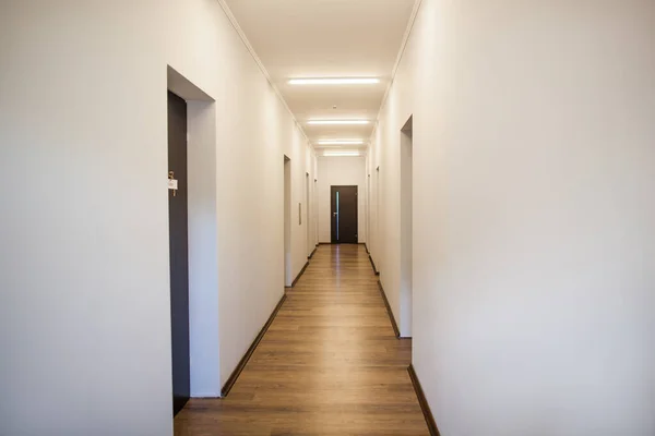 interior perspective of empty corridor with many doors